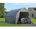 gray peak style portable garage with a black truck inside of it and man standing in front of it